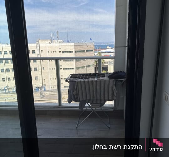 ויטרינת הזזה מאלומיניום כהה עם דלת רשת ביציאה למרפסת